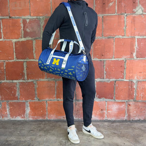 Man-Standing-With-University-of-Michigan-Duffle-Bag