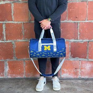 Man-Holding-University-of-Michigan-Duffle-Bag