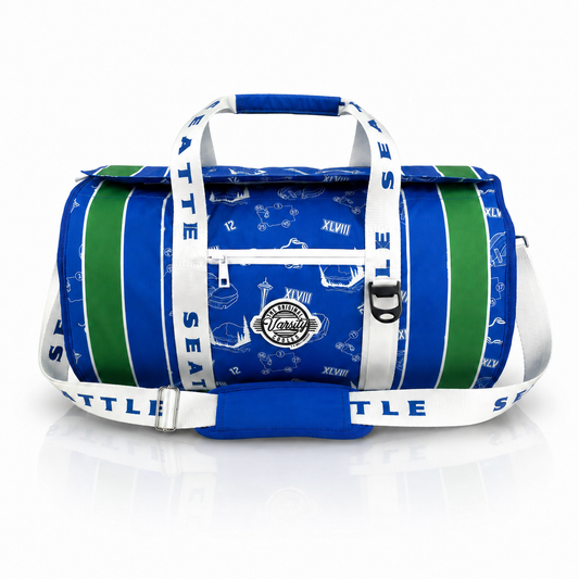 A Seattle Seahawks-themed duffel bag featuring royal blue and green vertical stripes, white shoulder straps with team text, and a central circular patch, shown on a white reflective background.